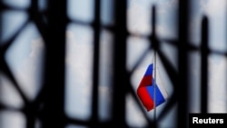 FILE - The Russian flag flies over the Embassy of Russia in Washington, Aug. 6, 2018.