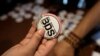 FILE - An Egyptian buys a pin with the Boycott, Divestment and Sanctions (BDS) logo during the launch of the Egyptian campaign that urges boycott, divestment and sanctions against Israel. The BDS campaign is behind the proposed boycott of Israeli universi