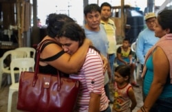 Guadalupe Severo, the wife of slain journalist Julio Valdivia, is embraced during his wake inside their home in Tezonapa, Veracruz, Mexico, Sept. 10, 2020. Valdivia's decapitated body was found five miles from Tezonapa a day earlier.