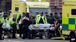 Emergency services transport an injured person to an ambulance, close to the Houses of Parliament in London, March 22, 2017.