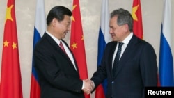 中國領導人習近平在訪問莫斯科期間與時任俄羅斯國防部長、現任俄羅斯聯邦安全會議秘書、前國防部長謝爾蓋·紹伊古（Sergei Shoigu）（右）握手。(資料圖片）