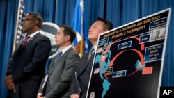 Law enforcement officials appear before a drug distribution poster during a news conference at the Justice Department in Washington, Oct. 17, 2017, to announce the indictments of two Chinese fentanyl trackers.