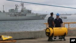 Sĩ quan hải quân Mỹ và thủy thủ đoàn đứng cạnh hệ thống định vị tham gia cuộc tìm kiếm máy bay Malaysia bị mất tích tại Perth, Australia, ngày 30/3/2014.