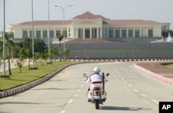 FILE - A police motorcycle approaches the President's Office in Naypyidaw, Myanmar, Dec. 1, 2011.