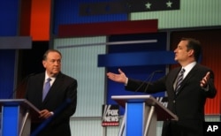 Sen. Ted Cruz, R-Texas, speaks as former Arkansas Gov. Mike Huckabee, left, listens during the first Republican presidential debate, Cleveland, IN, Aug. 6, 2015, in Cleveland.