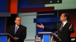 Sen. Ted Cruz, R-Texas, speaks as former Arkansas Gov. Mike Huckabee, left, listens during the first Republican presidential debate, Cleveland, IN, Aug. 6, 2015, in Cleveland. 