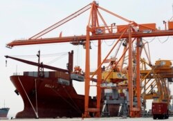 FILE - Shipping containers are loaded to a ship at a port in Hai Phong city, Vietnam, July 12, 2018.