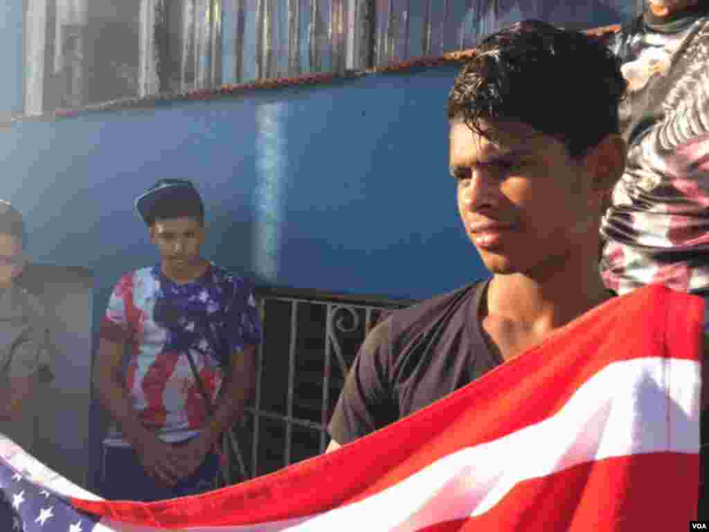 Young boys wear the colors of the American flag outside the U.S. Embassy minutes before the arrival of U.S. Secretary of State John Kerry for the official flag-raising ceremony, Aug. 14, 2015. (Celia Mendoza/VOA) 