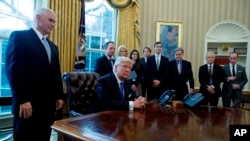 El presidente Donald Trump acompañado por el vicepresidente Mike Pence, y en espera los reporteros, antes de la firma de una orden ejecutiva en el oleoducto Keystone XL pipeline, el 24 de enero.