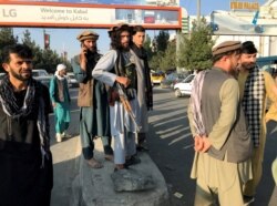 Seorang anggota Taliban (tengah) berdiri di luar Bandara Internasional Hamid Karzai di Kabul, Afghanistan, 16 Agustus 2021. (Foto: Reuters)