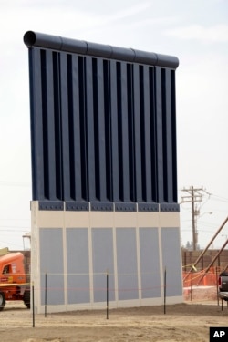 FILE - A border wall prototype stands near the border with Tijuana, Mexico, Oct. 19, 2017, in San Diego.