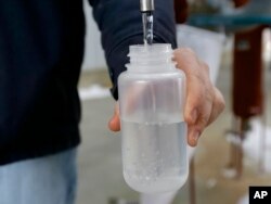 FILE - A sample bottle is filled with ethanol produced at the Green Plains ethanol plant in Shenandoah, Iowa, Jan. 6, 2015.