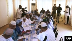 Mali's interim president, Dioncounda Traore (Back center R), speaks with ministers during a cabinet meeting at which a national state of emergency was declared, in Bamako, January 11, 2013.