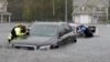 Members of the North Carolina Task Force urban search and rescue team check cars in a flooded neighborhood looking for residents who stayed behind as Florence continues to dump heavy rain in Fayetteville, N.C., Sunday, Sept. 16, 2018.