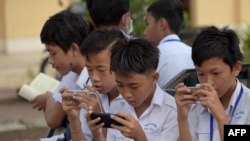 រូបឯកសារ៖ សិស្សានុសិស្សកំពុងប្រើទូរស័ព្ទស្មាតហ្វូន នៅក្នុងបរិវេណសាលារៀនមួយកន្លែងនៅរាជធានីភ្នំពេញ កាលពីថ្ងៃទី២៦ ខែមិថុនា ឆ្នាំ២០១៨។