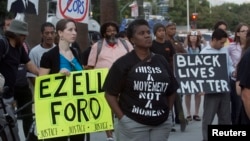 FILE - Protesters carry signs during a demonstration by Black Lives Matter in Los Angeles, August 11, 2015.