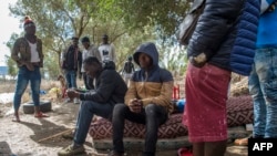 Des migrants d'Afrique subsaharienne dans une forêt du district de Boukhalef, à la périphérie sud-ouest de la ville portuaire marocaine de Tanger surplombant le détroit de Gibraltar, le 20 octobre 2018.