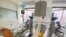 A medical staff is reflected in a mirror as she attends to a COVID-19 patient at a special ward at Arwyp Medical Centre, as South Africa is about the reach a milestone of 1 million infections, in Kempton Park, Dec. 25, 2020.
