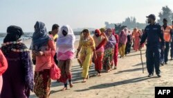 Members of the coast guard escort Rohingya refugees after their boat capsized, in Teknaf, near Cox's Bazar, Bangladesh, Feb. 11, 2020.