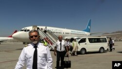Pilots of Ariana Afghan Airlines walk on the tarmac after landing at Hamid Karzai International Airport in Kabul, Afghanistan, Sept. 5, 2021.
