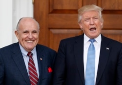 FILE - Then-President-elect Donald Trump calls out to media as he and former New York City Mayor Rudy Giuliani pose for photographs at the Trump National Golf Club, in Bedminster, New Jersey, Nov. 20, 2016.