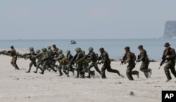 FILE - U.S. and Philippine marines storm the beach to simulate a raid during the joint U.S.-Philippines military exercise at the Naval Training Exercise Command, a former U.S. naval base, and facing the South China Sea at San Antonio township, Zambales province northwest of Manila, Philippines, May 9, 2014.
