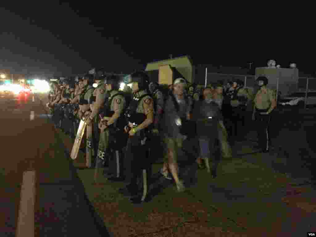 Police look on as protesters gather in Ferguson, Missouri, August 10, 2016. (Kane Farabaugh/VOA News)
