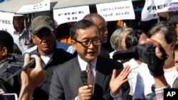 Opposition leader of Cambodia National Rescue Party Sam Rainsy, center, delivers a speech during a gathering to mark Human Rights Day, in front of National Assembly, in Phnom Penh, Cambodia, Wednesday, Dec. 10, 2014. (AP Photo/Heng Sinith)