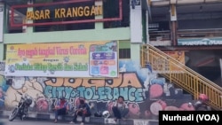 Petugas parkir duduk mengobrol di depan Pasar Kranggan, Yogyakarta yang sepi. (Foto:VOA/Nurhadi)