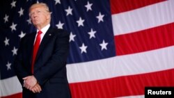 FILE - President Donald Trump stands in front of a U.S. flag.