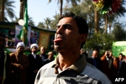 FILE - An Iraqi Muslim has a spike pierced into his tongue during a Sufi ritual in the Iraqi city of Hilla, south of Baghdad, Jan. 15, 2016.