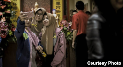 Tiga perempuan berhijab berfoto di kawasan Pecinan Bandung dalam tur Malam Imlek 2018 yang digelar Jaringan Kerja Antar-umat Beragama (Jakatarub) sejak 2013. (Courtesy: Kharisma Prima/Bandung Lautan Damai)