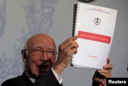 Advisor to Pakistan's PM on National Security and Foreign, Affairs Sartaj Aziz, shows dossiers allegedly on Indian intelligence agency's involvement in promoting terrorism in Pakistan, during a news conference at the Foreign Ministry in Islamabad, Aug. 22, 2015.