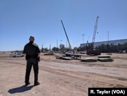 Border Patrol Sector Supervisor Jorge Rivera watches as construction workers build a portion of nine-meter-tall replacement fencing in Calexico, California.