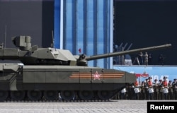 A Russian serviceman holds a red flag onboard a T-14 Armata tank after it stopped during a rehearsal for the Victory Day parade in Red Square in central Moscow, May 7, 2015.