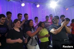 FILE - Ellis Hall, right, a rhythm-and-blues singer and an alumnus of the Perkins School for the Blind, rehearses with the Perkins Chorus, made up of visually impaired and blind students, for the school's annual gala in Watertown, Mass., May 7, 2015.