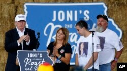 Republican presidential candidate Donald Trump shares the stage with the family of Sarah Root at a campaign event at the Iowa State Fairgrounds in Des Moines, Aug. 27, 2016. Root was killed this year after her car was hit by another. The driver, who was drunk, was a reportedly Honduran immigrant living in the country illegally.