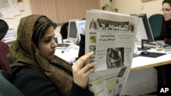 Iranian journalist Elahe Khosravi, reads Iranian daily newspaper Hamshahri, in Tehran, Iran on Tuesday, Feb. 7, 2006. The prominent Iranian newspaper said Tuesday it would hold a competition for cartoons on the Holocaust to test whether the West extends the principle of freedom of expression to the Nazi genocide as it did to the caricatures of the Prophet Muhammad.