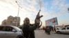 A Syrian anti-government fighter fires his rifle into the air in the streets of the west-central city of Hama on Dec. 5, 2024. 