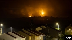 This picture taken from a position near Sderot along the Israeli border with the Gaza Strip early on Nov. 14, 2023, shows flares dropped by Israeli forces above the Palestinian territory.
