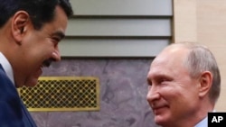El presidente de Venezuela, Nicolás Maduro, y el presidente de Rusia, Vladimir Putin, se saludan frente a la residencia Novo-Ogaryovo en Moscú, el 5 de diciembre de 2018.
