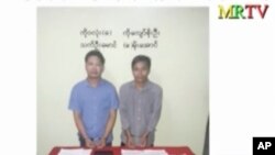 FILE - In this image released by the Myanmar Ministry of Information and broadcast by Myanmar's MRTV on Dec. 13, 2017, Reuters reporters Wa Lone, left, and Kyaw Soe Oo stand handcuffed in Myanmar.