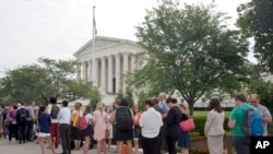 FILE - People stand in line hoping to enter the Supreme Court in Washington, Friday June 26, 2015. 
