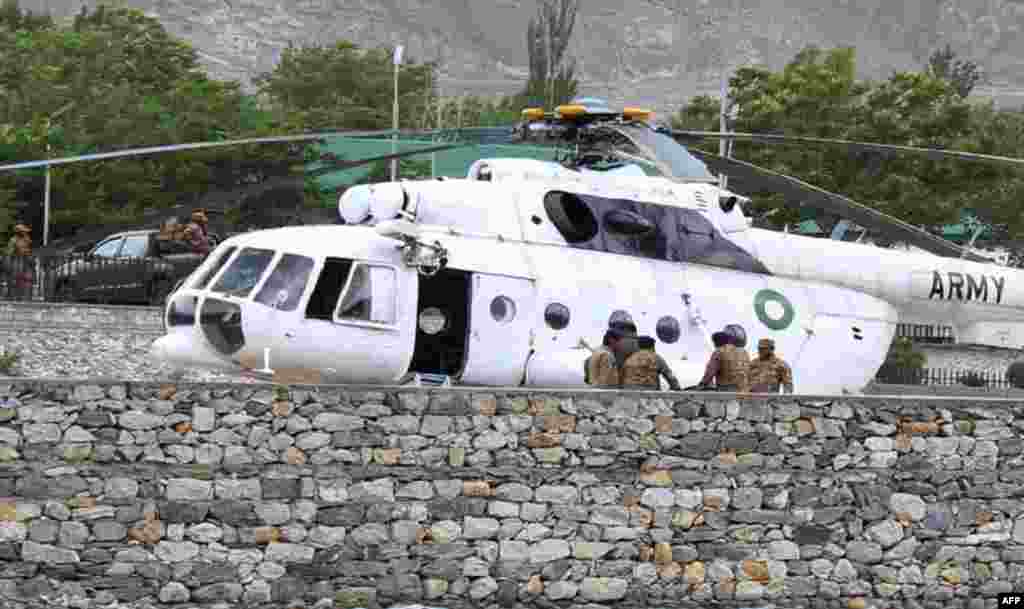 Pakistani soldiers gather beside an army helicopter at a military hospital where victims of a helicopter crash were brought for treatment in Gilgit, on May 8, 2015.