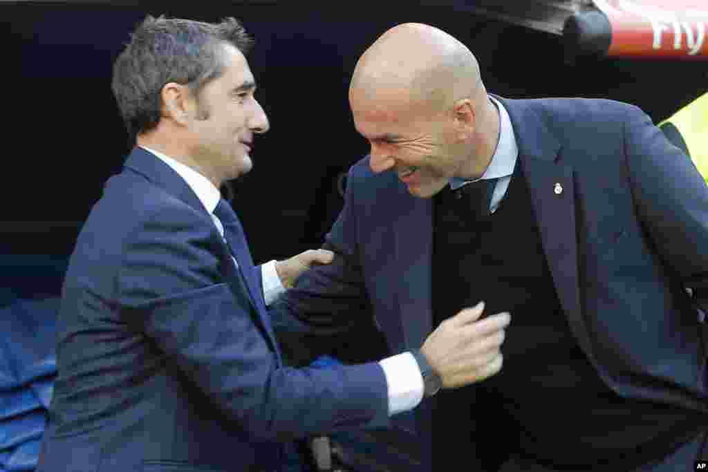 L'entraîneur du Barcelona, Ernesto Valverde, et l'entraîneur du Real Madrid Zinedine Zidane se saluent avant le début du match de football La Liga entre le Real Madrid et le Barcelone au stade Santiago Bernabeu de Madrid, le 23 décembre 2017.