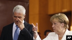 German Chancellor Angela Merkel, right, speaks as she gestures with Serbian President Boris Tadic, in Belgrade, Serbia, August 23, 2011