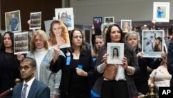 People in the audience hold up photos of their loved ones during the Senate Judiciary Committee's hearing on online child safety on Capitol Hill, Jan. 31, 2024 in Washington.