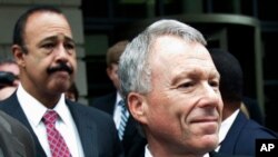 FILE - Former White House aide I. Lewis 'Scooter' Libby, right, is escorted to a waiting vehicle with his attorney, Theodore Well, left, outside federal Court in Washington, Thursday, June 14, 2007.