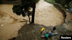 People recover some zinc sheets after a mudslide damaged their homes during heavy rains by Tropical Storm Nate in San Jose, Costa Rica, Oct. 5, 2017.