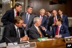 Members of the Senate committee speak together before Secretary of State John Kerry, Secretary of Energy Ernest Moniz and Secretary of Treasury Jack Lew arrive to testify at a Senate Foreign Relations Committee hearing on Capitol Hill, in Washington, July